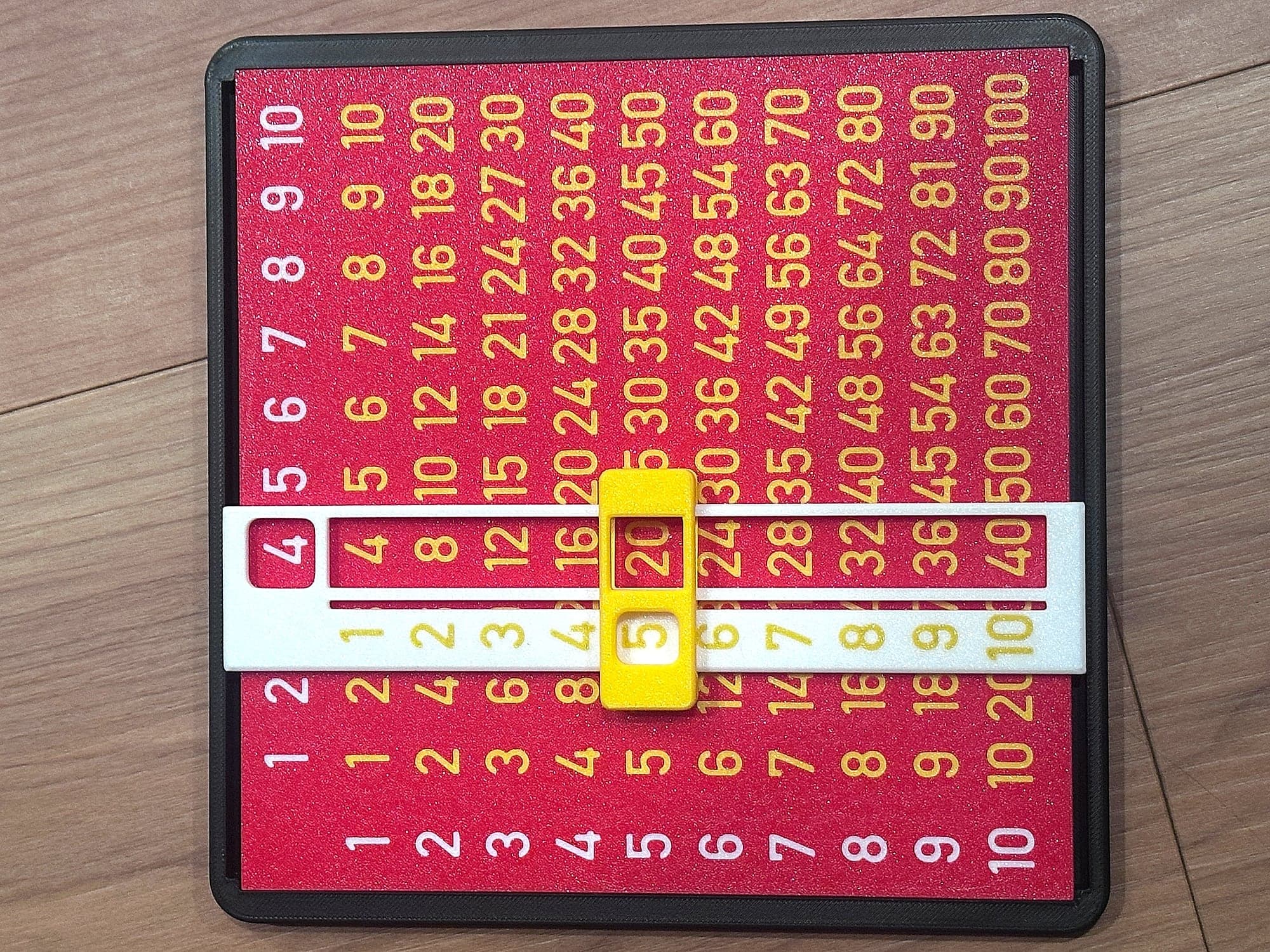 Red and gold multiplication slider board in a dark frame, made fresh for a party batch